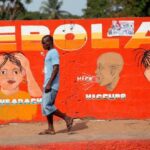 Un hombre camina junto a una pintura de concienciación sobre el ébola en una pared en el centro de Monrovia, capital de Liberia. (Foto: EFE)