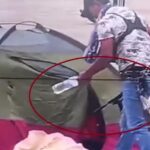 Hombre con fusil en campamento frente a EPM en Medellín