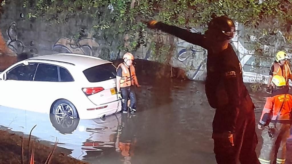 Bomberos rescata cuerpos de los fallecidos en carro en deprimido de Conquistadores